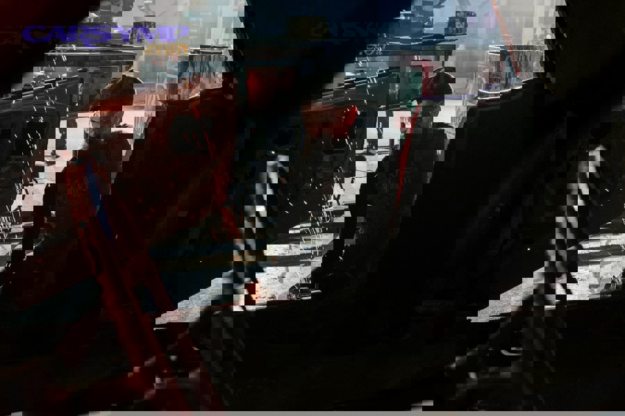 Mechanic comparing radiator, thermostat, and water pump issues