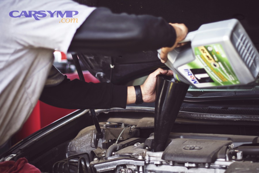 mechanic using walnut blasting equipment to clean engine intake valves