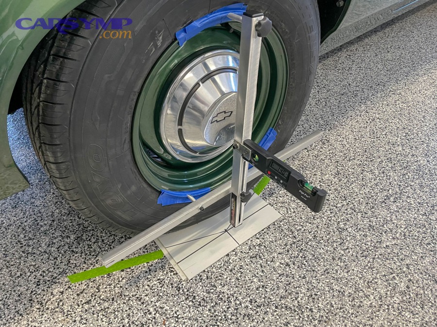 Mechanic inspecting suspension and steering components before alignment