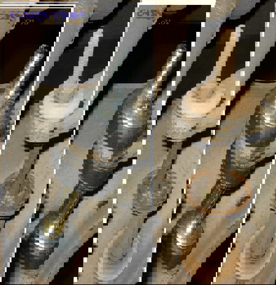 Close-up view of damaged sway bar link showing cracked bushings and worn ball joints